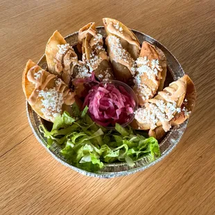 Crispy potato tacos topped with chipotle oaxacan style crema, side of shredded lettuce and citrus pickled onions.