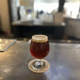 a glass of beer on a bar