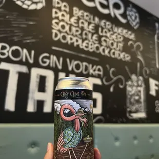 a hand holding a can of beer