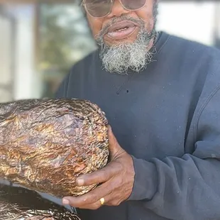 a man with a beard and a beardless face holding a bunch of bread