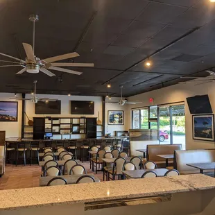 a restaurant with a bar and a ceiling fan