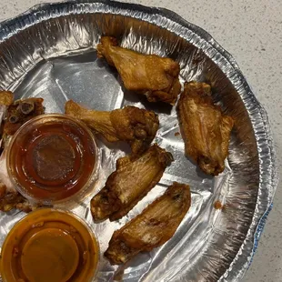 a plate of chicken wings and dipping sauce