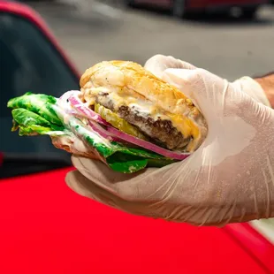 a hand holding a hamburger