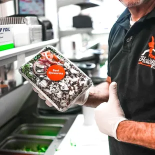 a man holding a box of halal