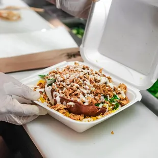 a person putting a container of food into a container