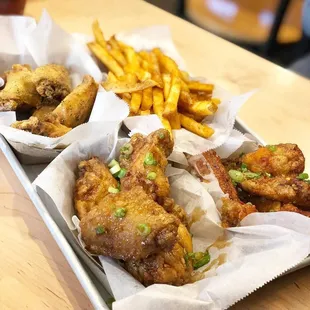 a tray of chicken wings and french fries
