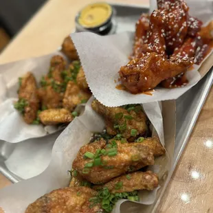 a tray of chicken wings with a side of dipping sauce