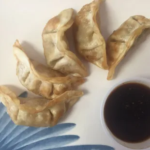 a plate of dumplings and dipping sauce