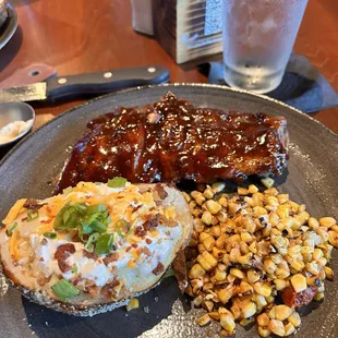 Ribs baked potato and corn