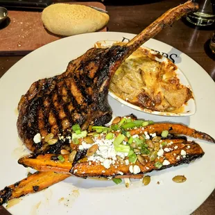Tomahawk Pork Chop, charred glazed carrots, southwestern au gratin potatoes