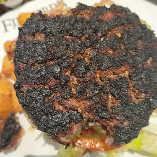 Medium well burnt burger covered by toppings and flipped over. I see you.  Dirty tables and crumb covered seats.
