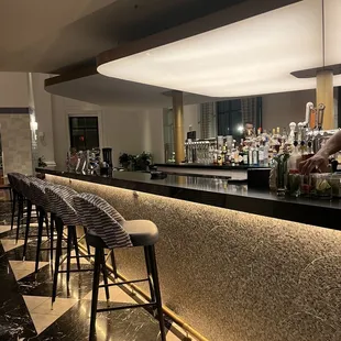 a bar with stools and a bar counter