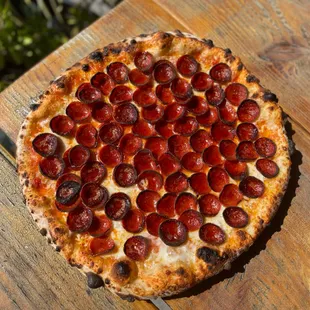 a pepperoni pizza on a wooden table