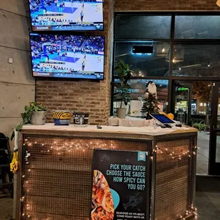 Inside restaurant - Hostess Stand - 2 large screen TVs set to NBA game
