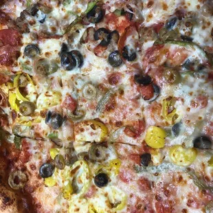 a pizza with pepperoni, olives, and peppers
