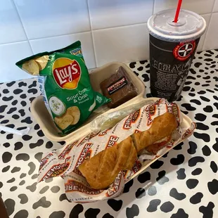 a hot dog, chips and a drink