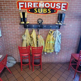 a fireman's coat hanging on a brick wall