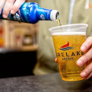a person pouring beer into a cup
