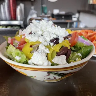 a bowl of salad and a pizza