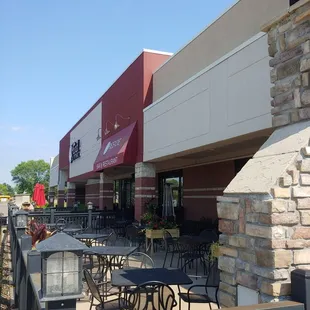 the outside of a restaurant with tables and chairs