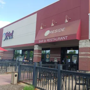 the outside of a restaurant with tables and umbrellas