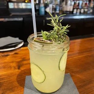 a glass of lemonade with a sprig of rosemary