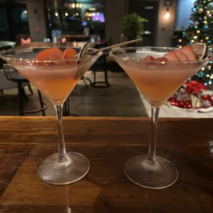 two cocktail glasses with a strawberry garnish