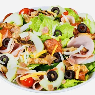 a salad with ham, olives, tomatoes, and cheese