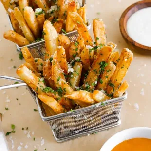 a basket of french fries with dipping sauce