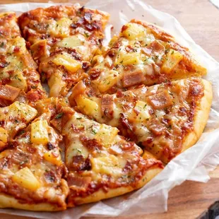 a sliced pizza on a wooden board