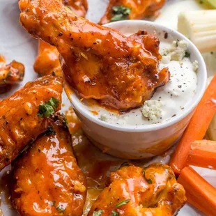 a bowl of buffalo wings and carrots