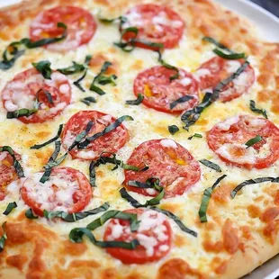 a pizza with tomatoes and basil