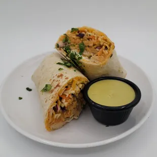 a burrito with a side of sauce