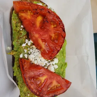 Avocado toast with tomato and feta cheese on multigrain bread