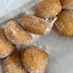 sugar coated doughnuts in a styrofoam container