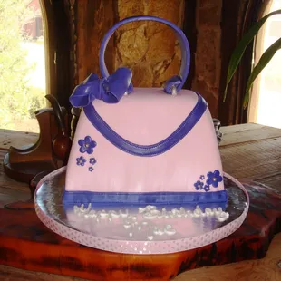 a pink and blue purse cake
