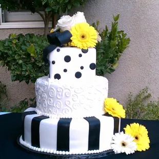 a black and white cake with yellow flowers