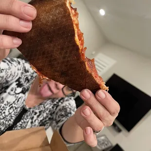 a woman holding a slice of pizza