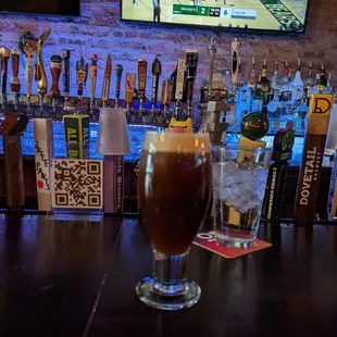 a glass of beer on a bar