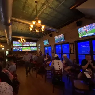 a large group of people watching a game on tvs