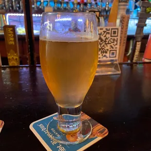 a glass of beer on a coaster