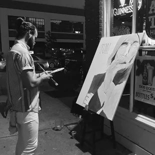 a man painting a picture of a woman