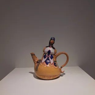 a woman sitting on a teapot