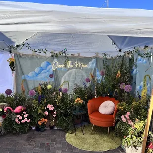 a flower stand with a chair and flowers