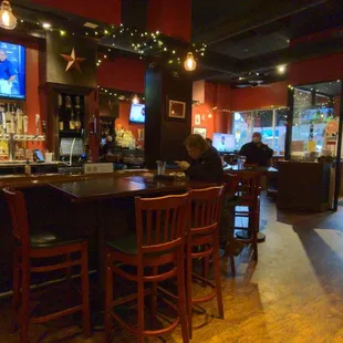 a bar with people sitting at the bar