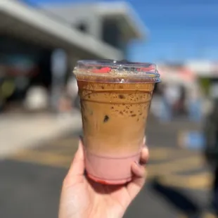 a hand holding a cup of iced coffee
