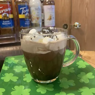 a cup of coffee with whipped cream and chocolate sprinkles