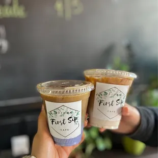 two people holding cups of coffee