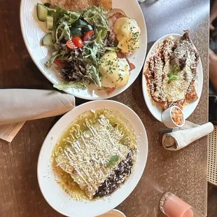 Left plate: Eggs Benedict  Right plate: Chile Verde Enchiladas w/ house-pressed Guava juice Front plate: Chilaquiles w/ Pico de Gallo