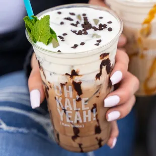 a woman holding a cup of iced coffee